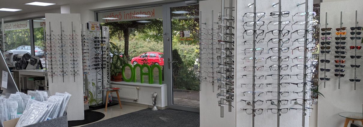 Vstup do prodejny se stojany obrub a nápisem kontaktní čočky na skle